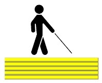  Figura stilizzata di un disabile visivo che percorre una pista tattile a pavimento